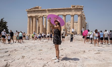 A woman takes a selfie in front of the Parthenon temple atop the Acropolis hill in Athens.