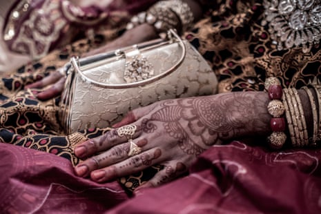 The decorated hands and full wedding attire of the bride on the wedding day