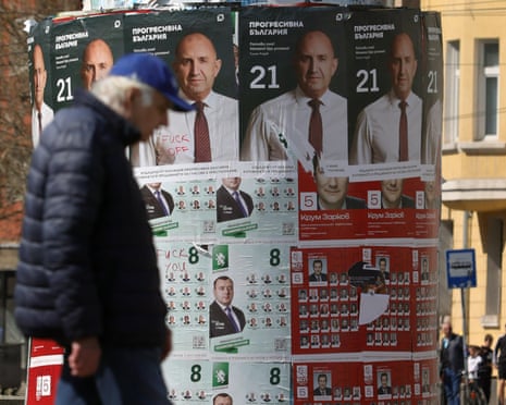 An elderly person passes posters of former president Rumen Radev, after Bulgaria's parliamentary election in Sofia.