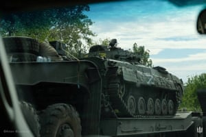 Ukrainian service members transport a Russian armoured fighting vehicle captured during the counteroffensive