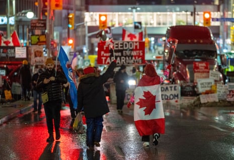 Protesters against Covid restrictions parade through the streets of Ottawa on the night of 11 February.