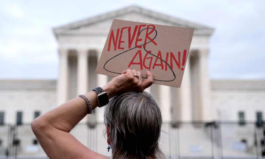 A pro-choice demonstrator holds a sign with a coat hanger, a symbol of the reproductive rights movement, in front of the US Supreme Court in Washington, DC.