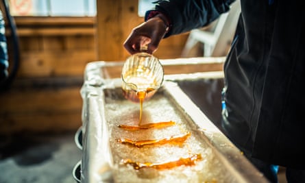 Pouring maple syrup onto snow at a sugar shack to make maple sugar taffy.