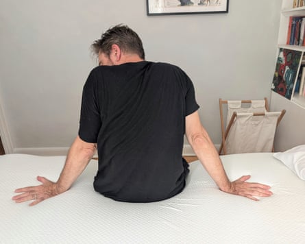 Writer Jane Hoskyn’s husband, Alan, sits on the Panda Bamboo mattress topper to test its heat retention.