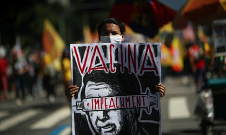 A protestor holds a banner in which reads “Vaccine” and “Impeachment” during a demonstration in Rio de Janeiro against Brazil’s President Jair Bolsonaro.
