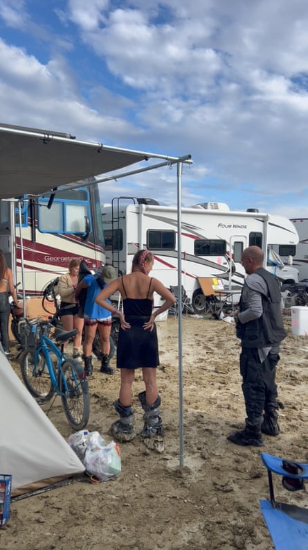 people wearing makeshift boots stand in the mud