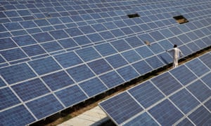 A worker cleans solar panels at the Azure solar plant in Khadoda