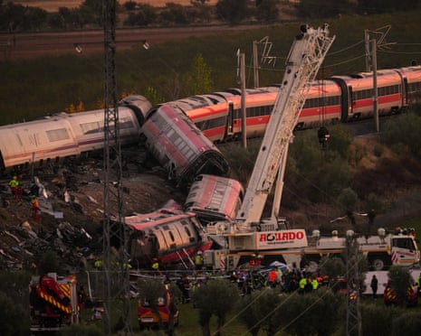 Derailed, crumpled train carriages in Urda, Spain, as cranes and emergency crews work nearby