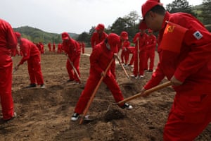 Party members participate in a team-building event as they sow pumpkins near a former academy of China’s Communist Party at Nanniwan during a government-organised tour in Yanan