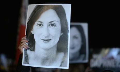 Protesters hold pictures of Daphne Caruana Galizia as they gather outside the prime ministers’s office in Valletta, Malta, the day Yorgen Fenech was detained on his yacht.