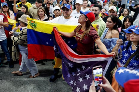 People hold a Venezuelan and US flag as they react to the news that the US struck Venezuela and captured its president, Nicolás Maduro, in Doral, Miami-Dade county, Florida.