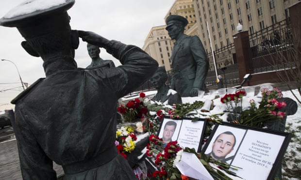 Photographs of the pilot Oleg Peshkov, left, and rescuer Alexander Pozynich at a monument to Soviet officers in Moscow