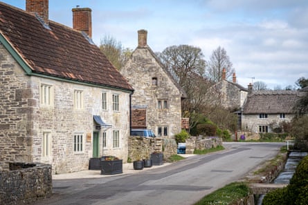 A village street with stone houses with slate and thatched roofs