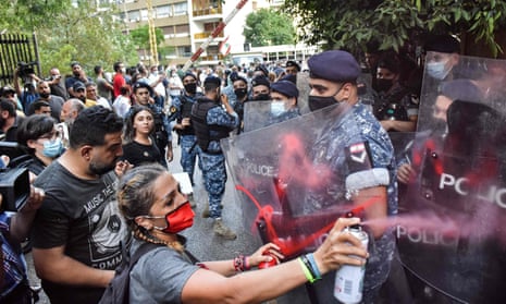 Demonstrators spray the shields of riot police during a protest by the families of the Beirut blast victims.