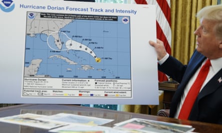Donald Trump holds a chart showing Hurricane Dorian