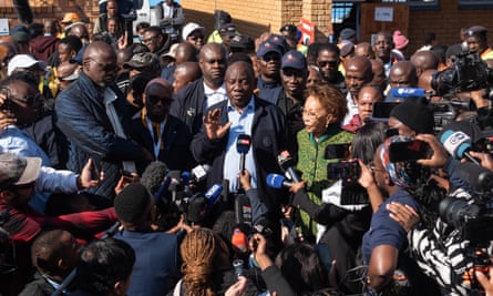 Cyril Ramphosa speaks at the centre of a throng of journalists