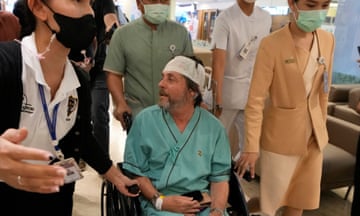 Man in wheelchair surrounded by support staff