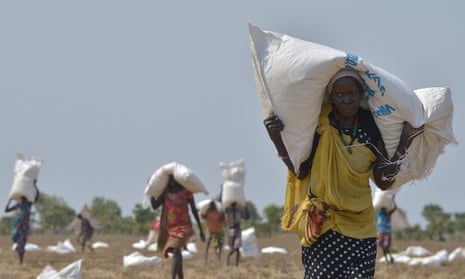 A woman carries a sack of food aid after a food-drop in Panyijar county, South Sudan.