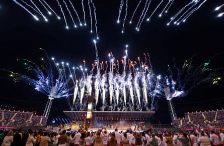 Fireworks explode, with spectators in the foreground