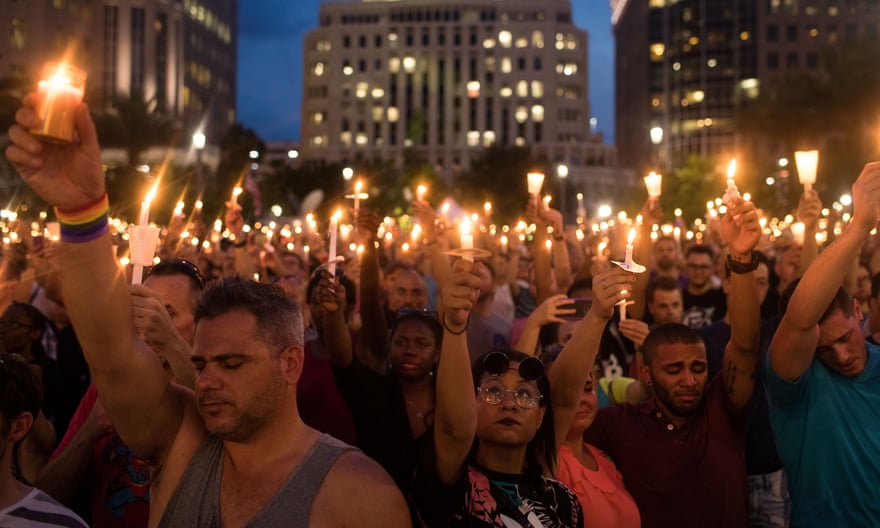 People hold candles during an evening memorial service for the victims on 13 June 2016 in Florida.