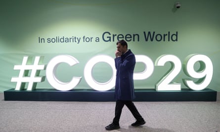 A man walks past an installation with the Cop29 logo