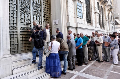 People wait to enter a bank branch in Athens this morning.