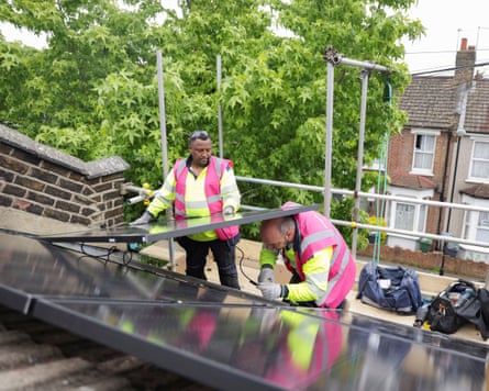 Roofers installing solar panels on Edelstyn and Powell’s house in 2023.