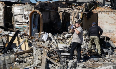 People survey a damaged private building after an overnight rocket attack in Krasylivka village, near Kyiv, Ukraine, 8 May 2024 amid the Russian invasion.