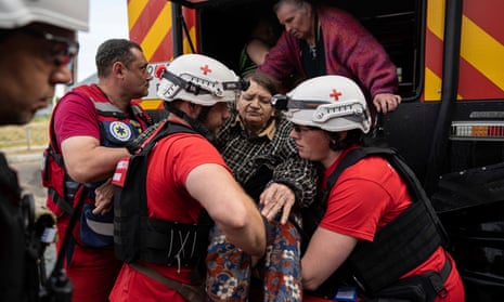 Ukrainian Red Cross volunteers help an elderly woman