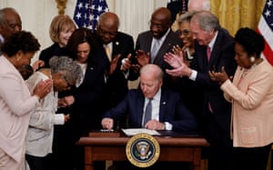 Joe Biden is applauded as he reaches for a pen to sign the Juneteenth National Independence Day Act into law.