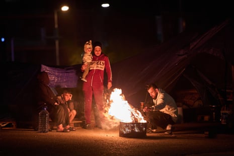 A displaced family, who fled Israeli bombings in southern Lebanon, make a bonfire next to a tent in Beirut