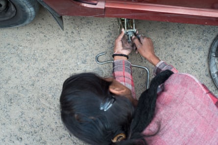 Hemlata changes a flat tire as part of a professional driving workshop.