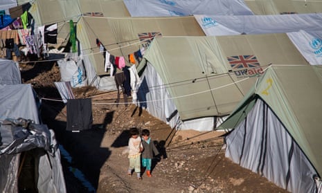 Children walk through a camp in northern Iraq housing people displaced by Isis attacks