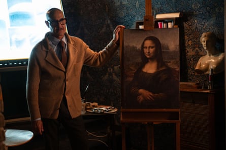 Tucci is standing in a room beside a copy of the Mona Lisa