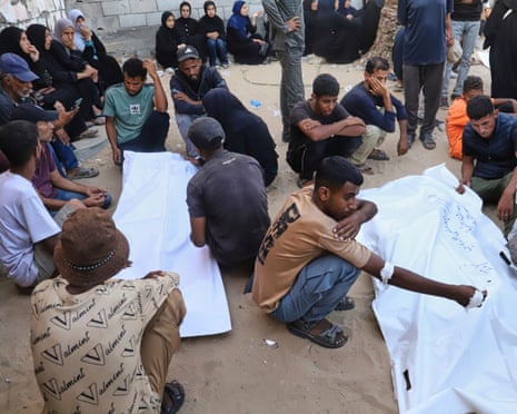 Relatives of Palestinians killed at an aid distribution centre mourn over their bodies during their funeral at Nasser hospital in Khan Younis, southern Gaza Strip, on Saturday, July 19, 2025.