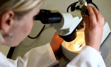 A women looking through a microscope.