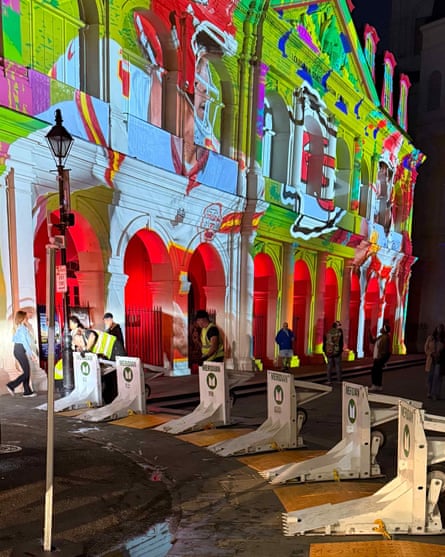 Movable barriers outside a building with images being projected upon it.