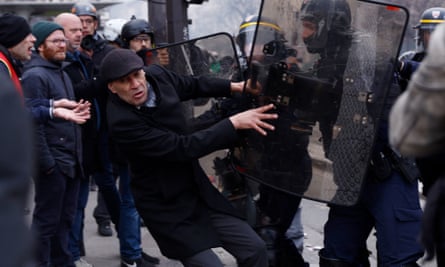 A protester is pushed by French riot police during a demonstration as part of the tenth day of nationwide strikes and protests against French government’s pension reform, in Paris, France, 28 March 2023.