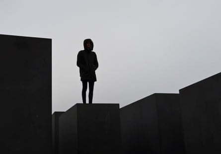 A young man stands on a stone of the holocaust memorial in Berlin, Germany, November 26, 2016.