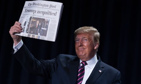 Donald Trump holds up a copy of the Washington Post with the headline 'Trump Acquitted'