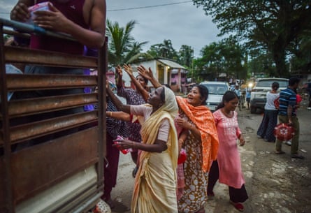 People being handed food at the back of a truck