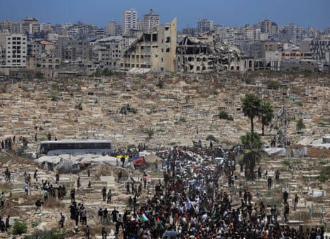 A funeral procession makes its way through largely destroyed Gaza City.