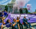 people chant and hold signs at a rally