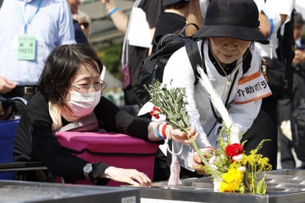 People offer flowers after the memorial ceremony in Hiroshima.