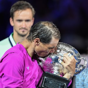 Daniil Medvedev looks on as Rafael Nadal kisses the Norman Brookes Challenge Cup as he celebrates winning his 21st Grand Slam title