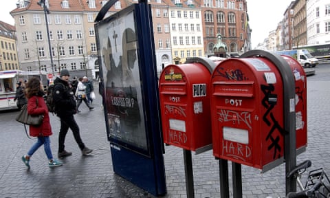 People walking past two red postboxes in Copenhagen