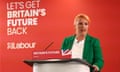 Louise Haigh stands at a podium at the Trainline headquarters. Behind her is a Labour sign reading 'Let's get Britain's future back'.