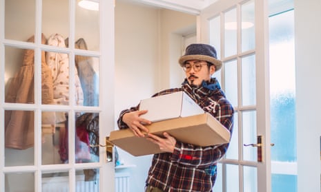 Young handsome Asian man receiving home delivered parcels in new house
