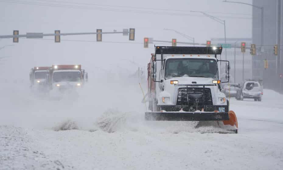Snow ploughs work to clear a road during a winter storm on Sunday.