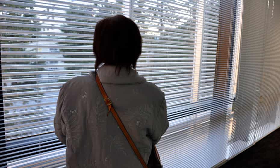A victim of forced sterilisation in Japan faces a window
